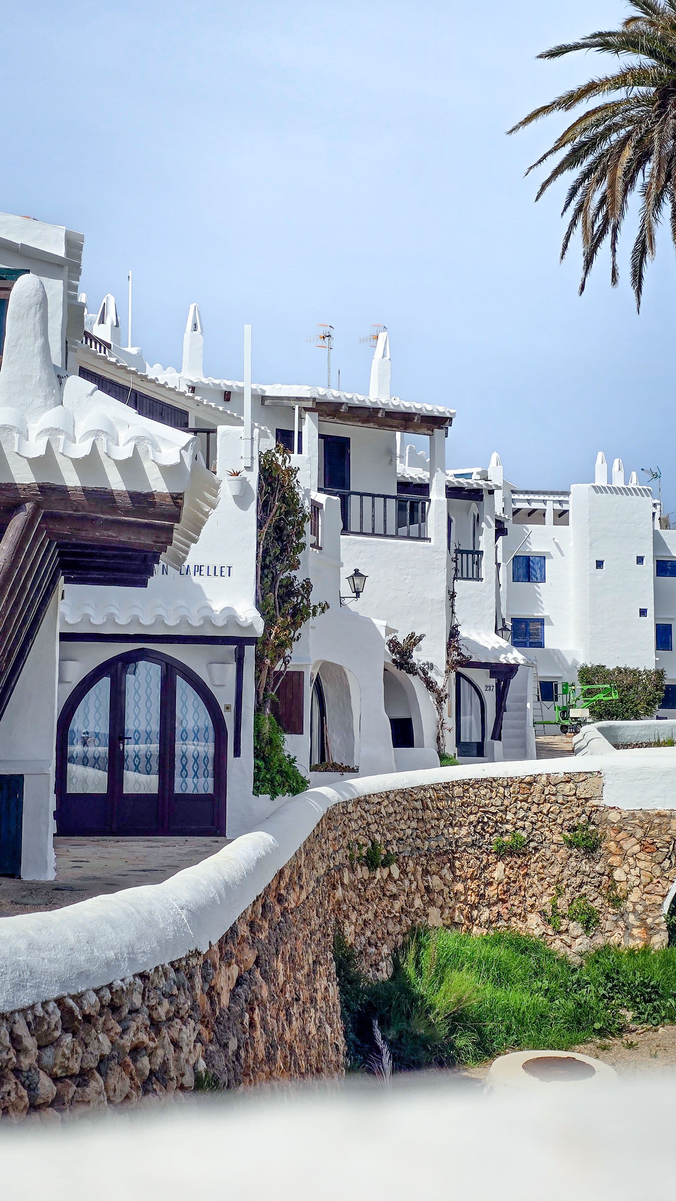 Arquitectura blanca y muro de piedra tradicional de Binibeca